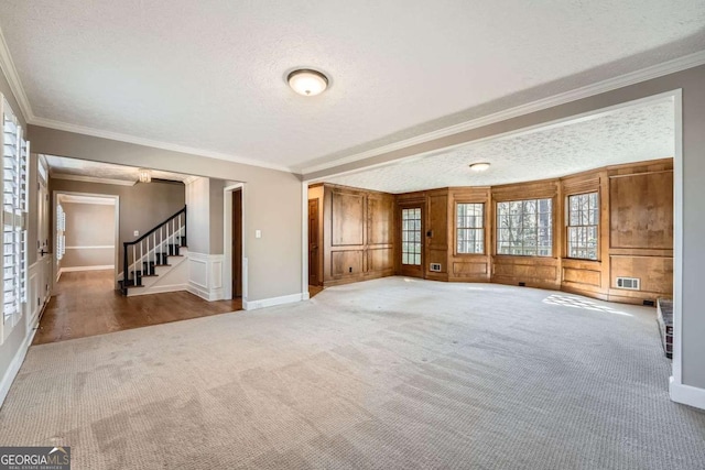 interior space with stairs, visible vents, a textured ceiling, and ornamental molding