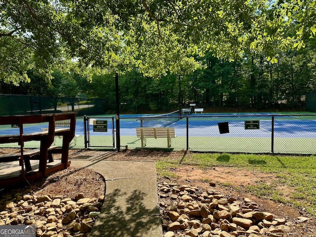 view of pool with a tennis court, a gate, and fence