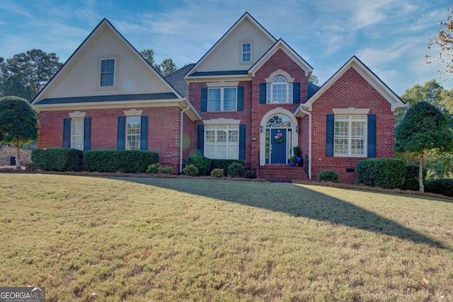 traditional-style house featuring roof with shingles, brick siding, crawl space, and a front yard