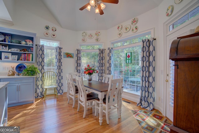 dining area featuring lofted ceiling, light wood-style floors, visible vents, and a ceiling fan