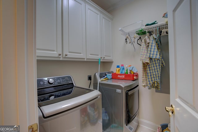 clothes washing area featuring washing machine and dryer and cabinet space