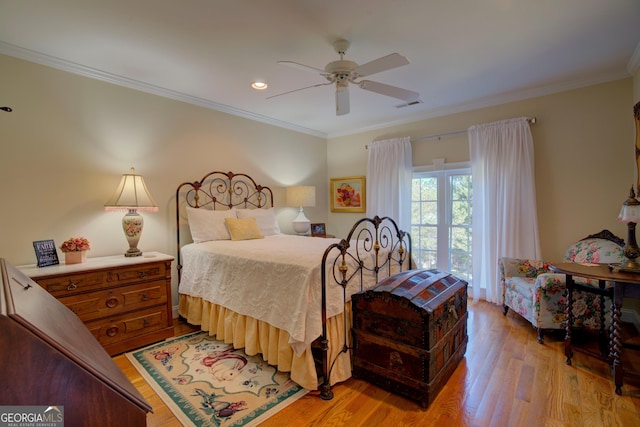 bedroom featuring light wood-style flooring, visible vents, ceiling fan, and ornamental molding