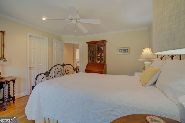 bedroom featuring a ceiling fan, baseboards, crown molding, and light wood finished floors