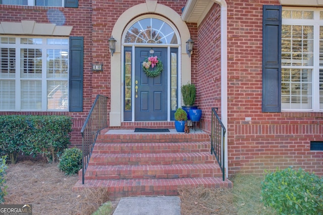 view of exterior entry with brick siding