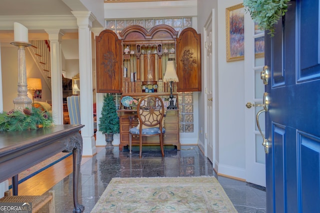 entryway with stairs, marble finish floor, decorative columns, and baseboards