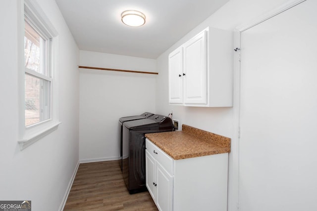 laundry area with light wood finished floors, cabinet space, washer and dryer, and baseboards