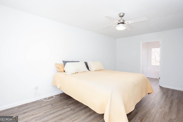 bedroom with ceiling fan, baseboards, and wood finished floors