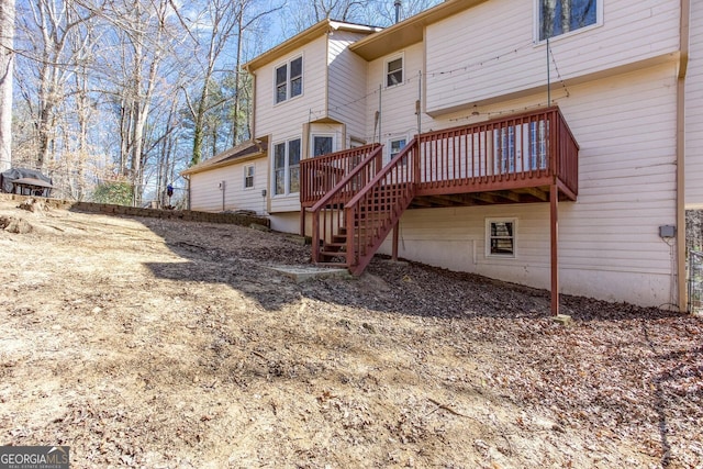 rear view of property featuring stairway and a wooden deck