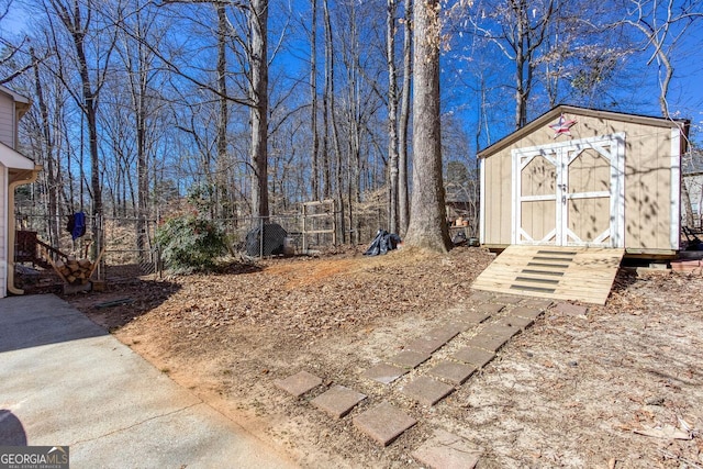 view of yard featuring a storage shed, an outdoor structure, and fence