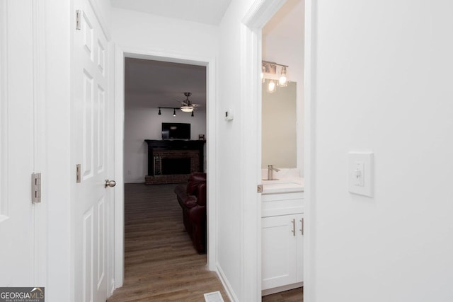 hall featuring a sink and wood finished floors