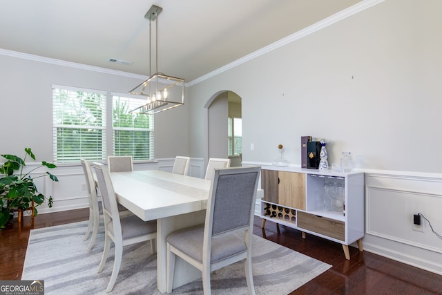 dining area featuring ornamental molding, visible vents, arched walkways, and wainscoting