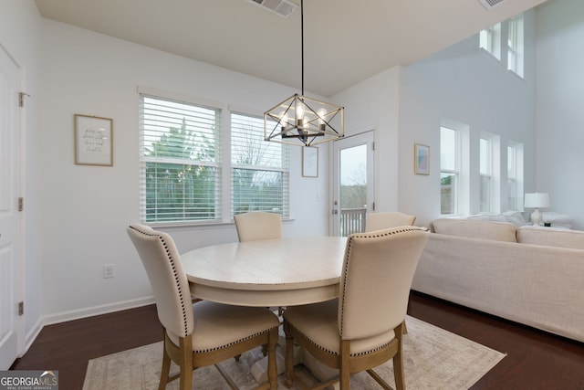 dining room featuring a notable chandelier, dark wood-style floors, visible vents, and baseboards