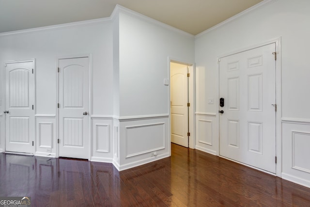 foyer entrance featuring wainscoting, a decorative wall, ornamental molding, and wood finished floors