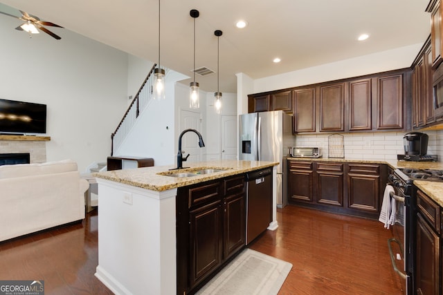 kitchen featuring visible vents, open floor plan, stainless steel dishwasher, gas stove, and a sink