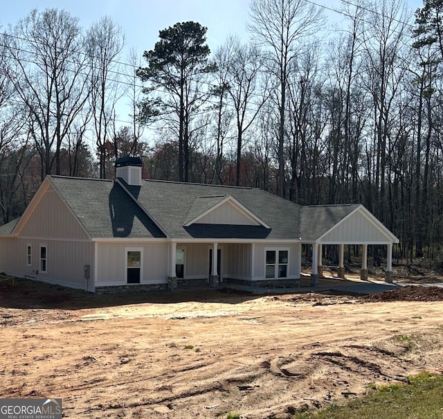 view of front of house featuring a shingled roof and a chimney