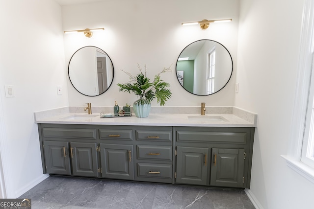 full bathroom featuring marble finish floor, double vanity, and a sink