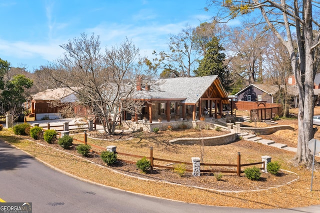 view of front facade featuring a patio area and fence