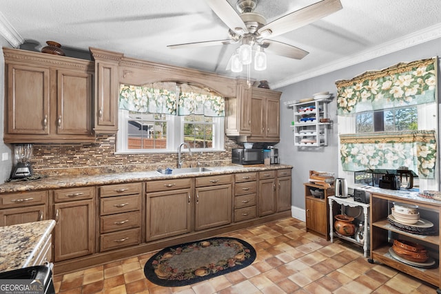 kitchen with black microwave, a sink, ornamental molding, brown cabinets, and tasteful backsplash