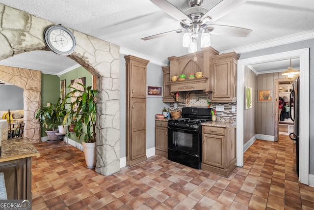 kitchen with light stone counters, backsplash, crown molding, and gas stove