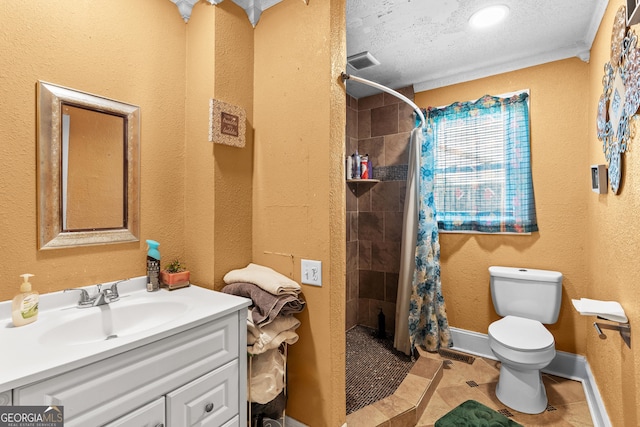 bathroom featuring visible vents, tiled shower, vanity, and toilet