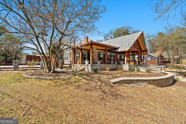 view of side of home with a shingled roof, a chimney, and a lawn