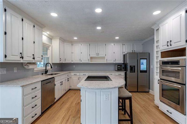 kitchen featuring a kitchen island, a sink, white cabinetry, appliances with stainless steel finishes, and open shelves