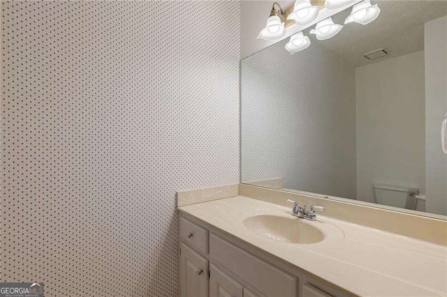 bathroom featuring toilet and vanity