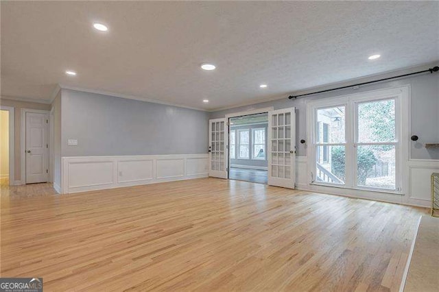 unfurnished living room with a textured ceiling, ornamental molding, light wood-style flooring, and recessed lighting