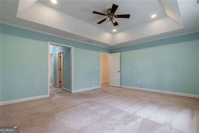 carpeted spare room featuring a tray ceiling, recessed lighting, and baseboards