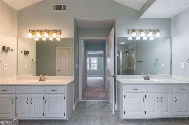 full bathroom featuring a stall shower, lofted ceiling, visible vents, and a sink