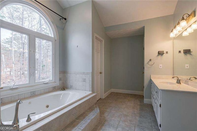 bathroom featuring baseboards, a tub with jets, tile patterned flooring, and vanity