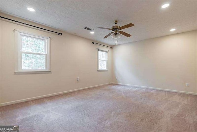 carpeted empty room with visible vents, baseboards, a ceiling fan, a textured ceiling, and recessed lighting