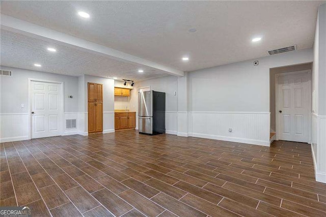 spare room featuring wood finish floors, wainscoting, visible vents, and recessed lighting