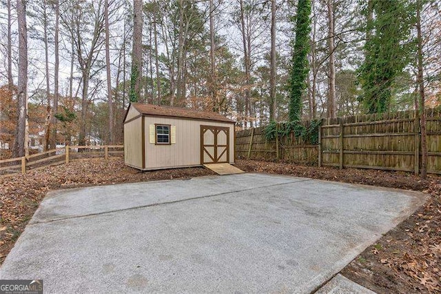 view of patio / terrace featuring an outbuilding, a fenced backyard, and a storage shed