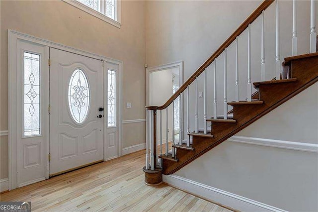 foyer featuring stairs, baseboards, and wood finished floors