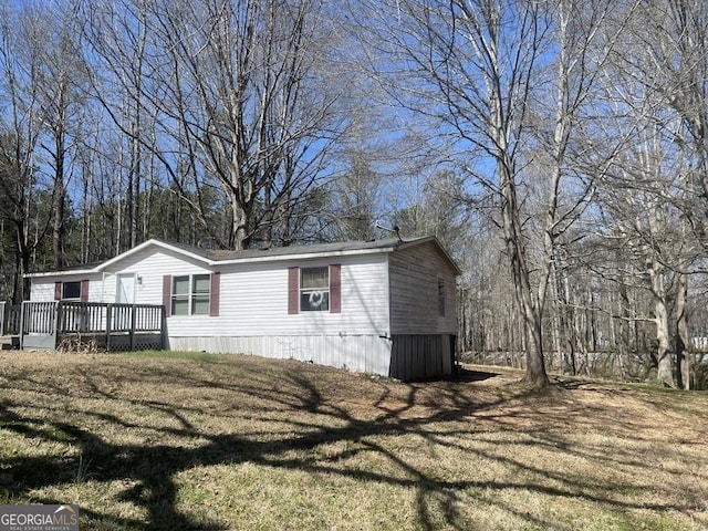 view of side of property with a wooden deck and a yard