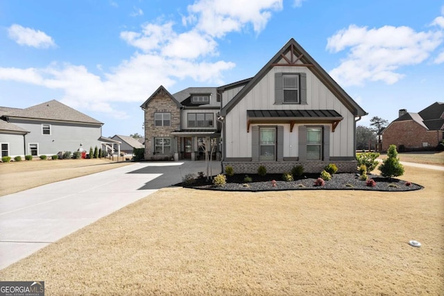 view of front of property with metal roof, brick siding, driveway, board and batten siding, and a standing seam roof