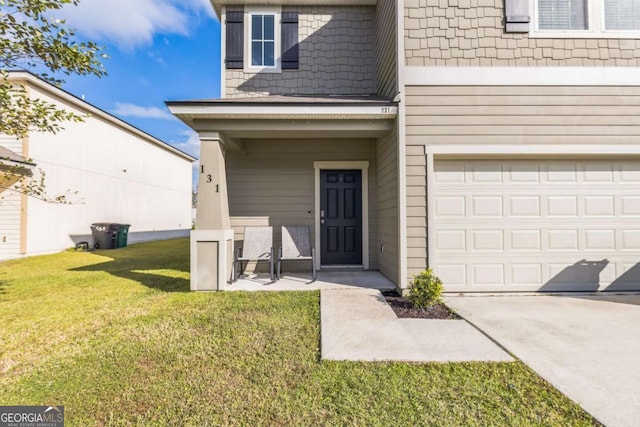 property entrance featuring an attached garage and a yard