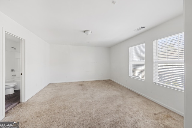 spare room with visible vents, baseboards, and carpet