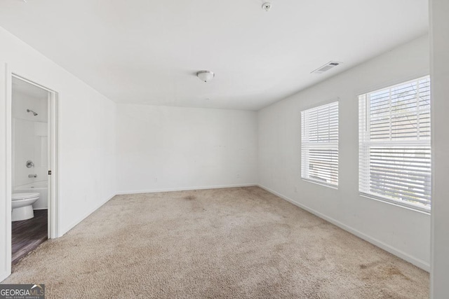 carpeted spare room with visible vents and baseboards