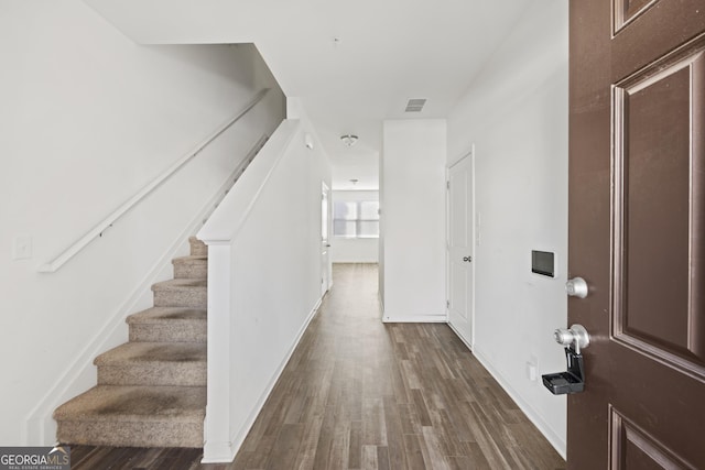 entrance foyer featuring stairs, dark wood-type flooring, and visible vents