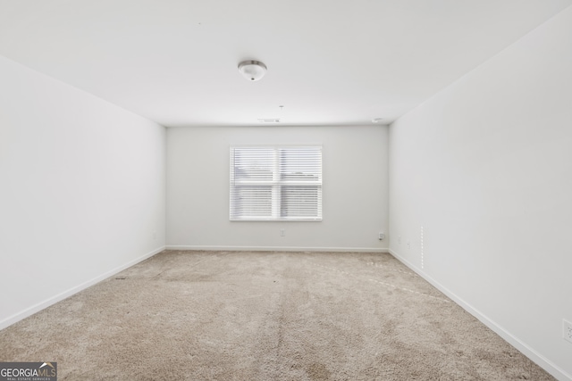 carpeted empty room with baseboards