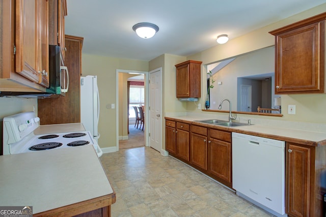 6935 Autumn Hills Dr, Cumming, GA 30028 - kitchen featuring brown cabinetry, a sink, white appliances, and light countertops