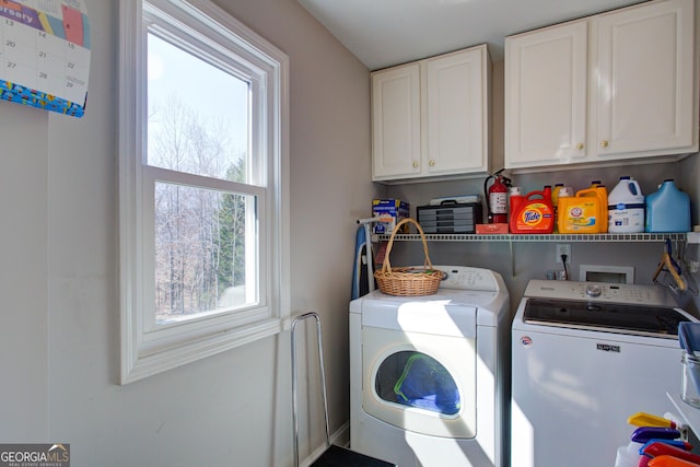 clothes washing area featuring cabinet space and washing machine and dryer