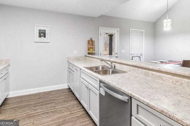 kitchen with dishwasher, lofted ceiling, light wood-style flooring, light countertops, and a sink