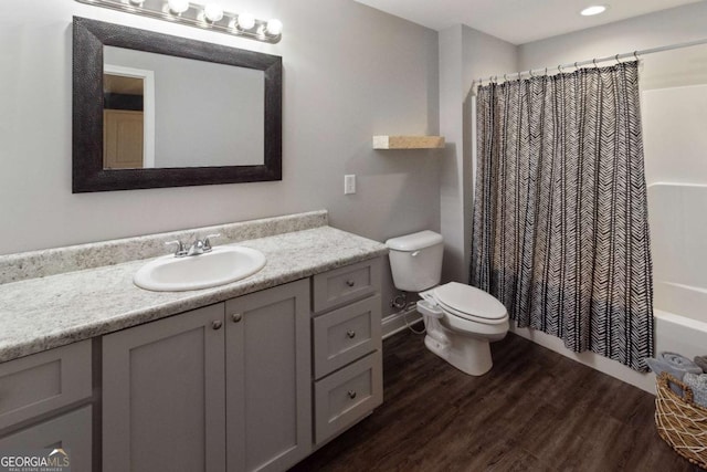 full bathroom featuring toilet, shower / tub combo with curtain, wood finished floors, and vanity