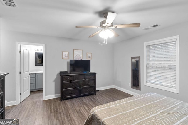 bedroom featuring a ceiling fan, baseboards, visible vents, and wood finished floors