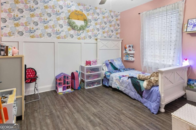 bedroom with a ceiling fan, wood finished floors, and wainscoting