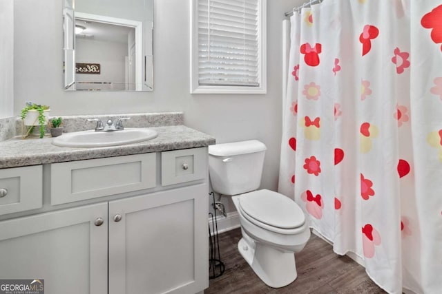 full bathroom featuring baseboards, toilet, wood finished floors, curtained shower, and vanity