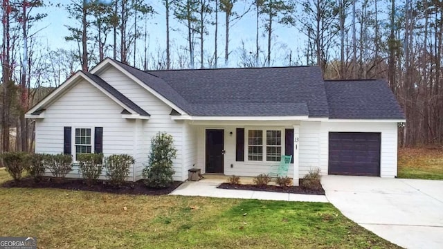 ranch-style house with an attached garage, roof with shingles, concrete driveway, and a front yard